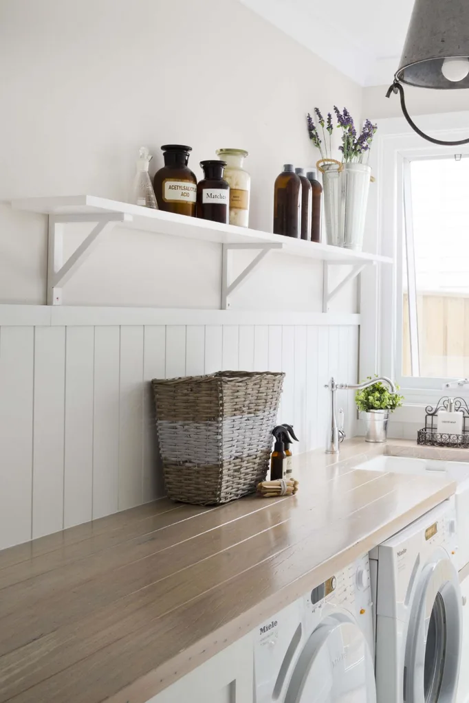 White laundry with VJ panelled splashback and timber benchtop