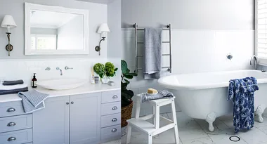 Elegant bathroom with a clawfoot tub, white vanity, large mirror, and striped towels, decorated with plants and accessories.