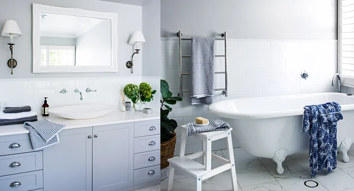 Elegant bathroom with a clawfoot tub, white vanity, large mirror, and striped towels, decorated with plants and accessories.