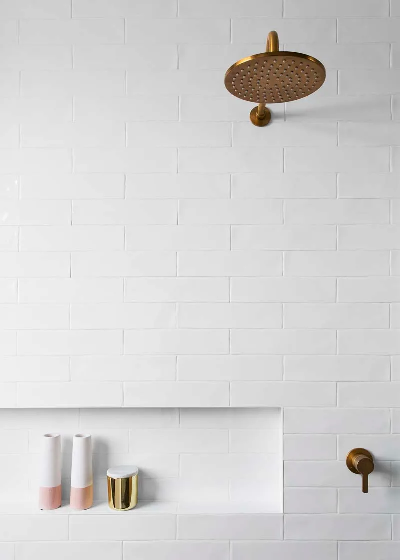 Shower niche with brushed brass tapware and rain head