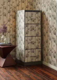 Patterned wallpaper room with matching cabinet, wooden floor, decorative table, and glass vases.