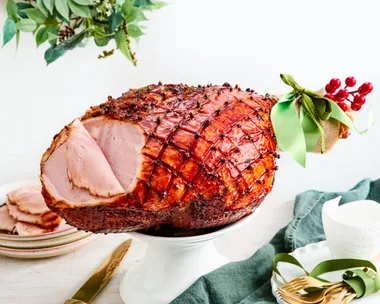 chirstmas ham with green ribbon on the end and garland in the background