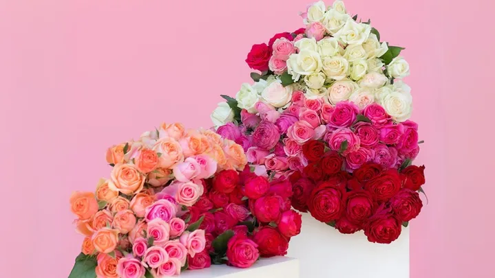 bunches of rose bouquets in red white orange and pink on small white pedestals