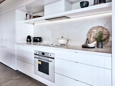 kitchen with oven built in and white cupboard surrounding it