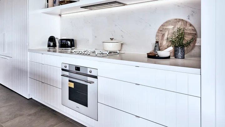 kitchen with oven built in and white cupboard surrounding it