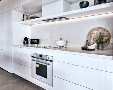 kitchen with oven built in and white cupboard surrounding it