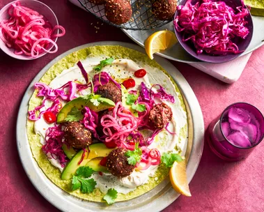 open wrap with purple pickled onion and beetroot on top of falafel