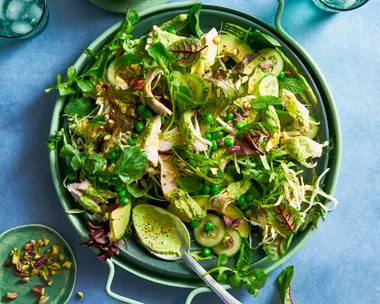 green salad with peas and salad with spoon sticking out and handle bowl