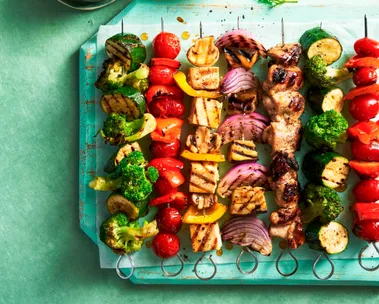 vegie skewers with tofu and meat on them in a line resembling rainbow colours