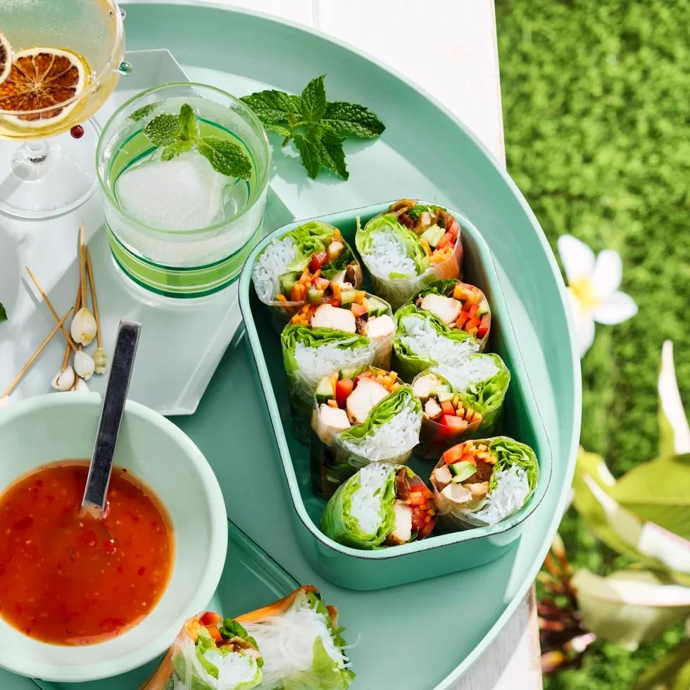 chicken teriyaki rolls in lunchbox with bowl of sauce next to it
