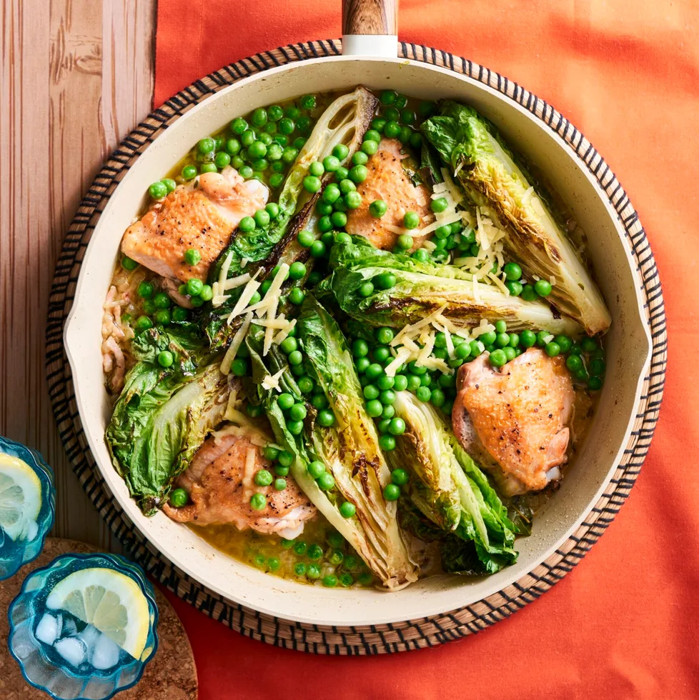 chicken peas bacon and charred lettuce in pan with sprinkle of herbs on top