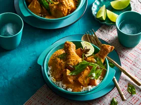 chicken curry in two bowls orangey colour with blue and teal colouring of bowls