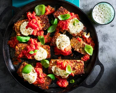 parmigiana meatloaf with basil on top in black casserole dish