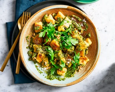 pesto gnocchi with basil pine nuts and rocket on top