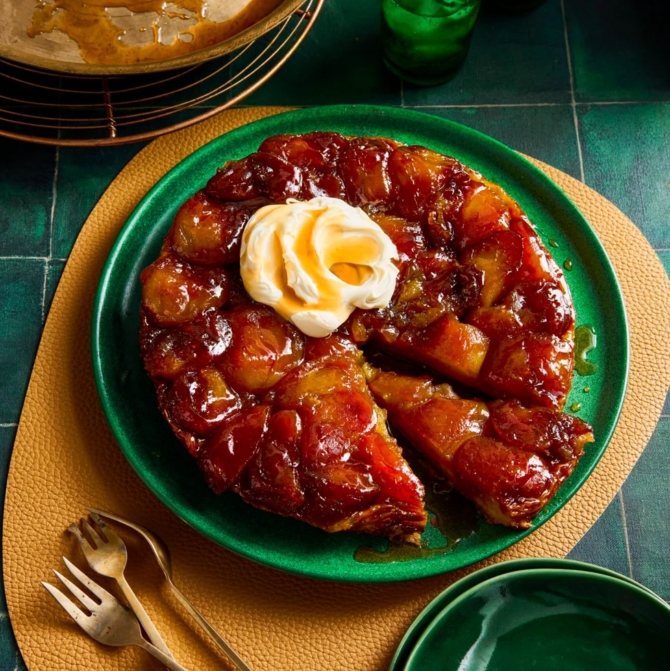 apple tarte tatin with dollop of double cream on top in green bowl