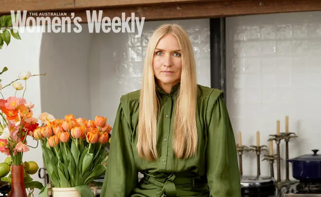 Blonde woman in green dress sitting in kitchen with orange tulips; Australian Women's Weekly cover.