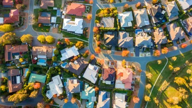 Aerial view of a suburban neighborhood with houses, trees, and winding roads.