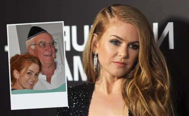 Isla Fisher posing on a red carpet; inset photo shows her smiling with an older man wearing glasses and a yarmulke.