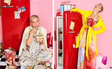 Woman in colorful outfits beside a red fridge, eating cereal and posing joyfully in a vibrant kitchen setting.