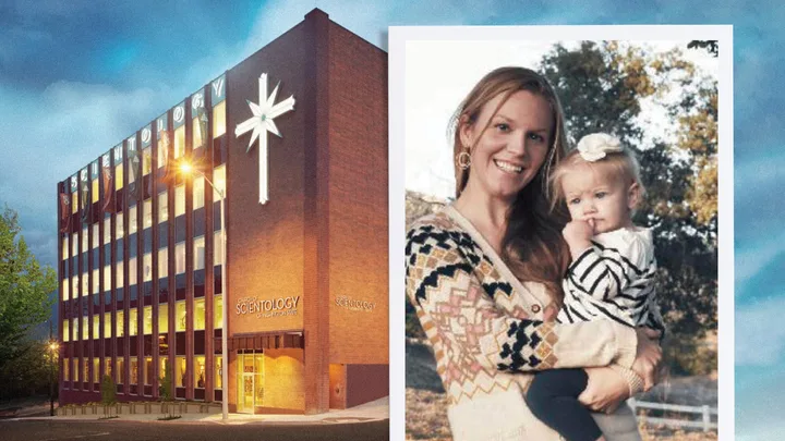 A Scientology building beside a smiling woman holding a young child outdoors.