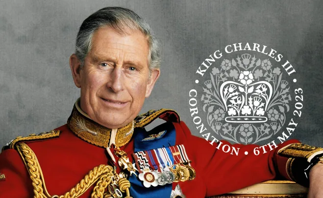 King Charles III in red military attire, coronation emblem and date: 6th May 2023.