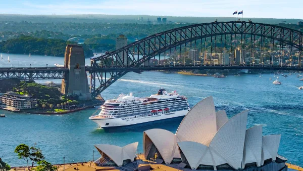 Cruise ship near Sydney Opera House and Harbour Bridge on a sunny day.
