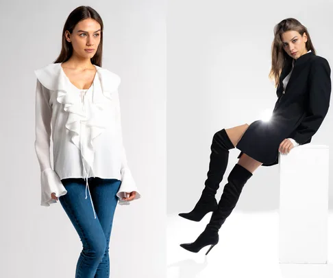 Two women in winter fashion: one in a white ruffled blouse and jeans, the other in a black blazer dress with high boots.
