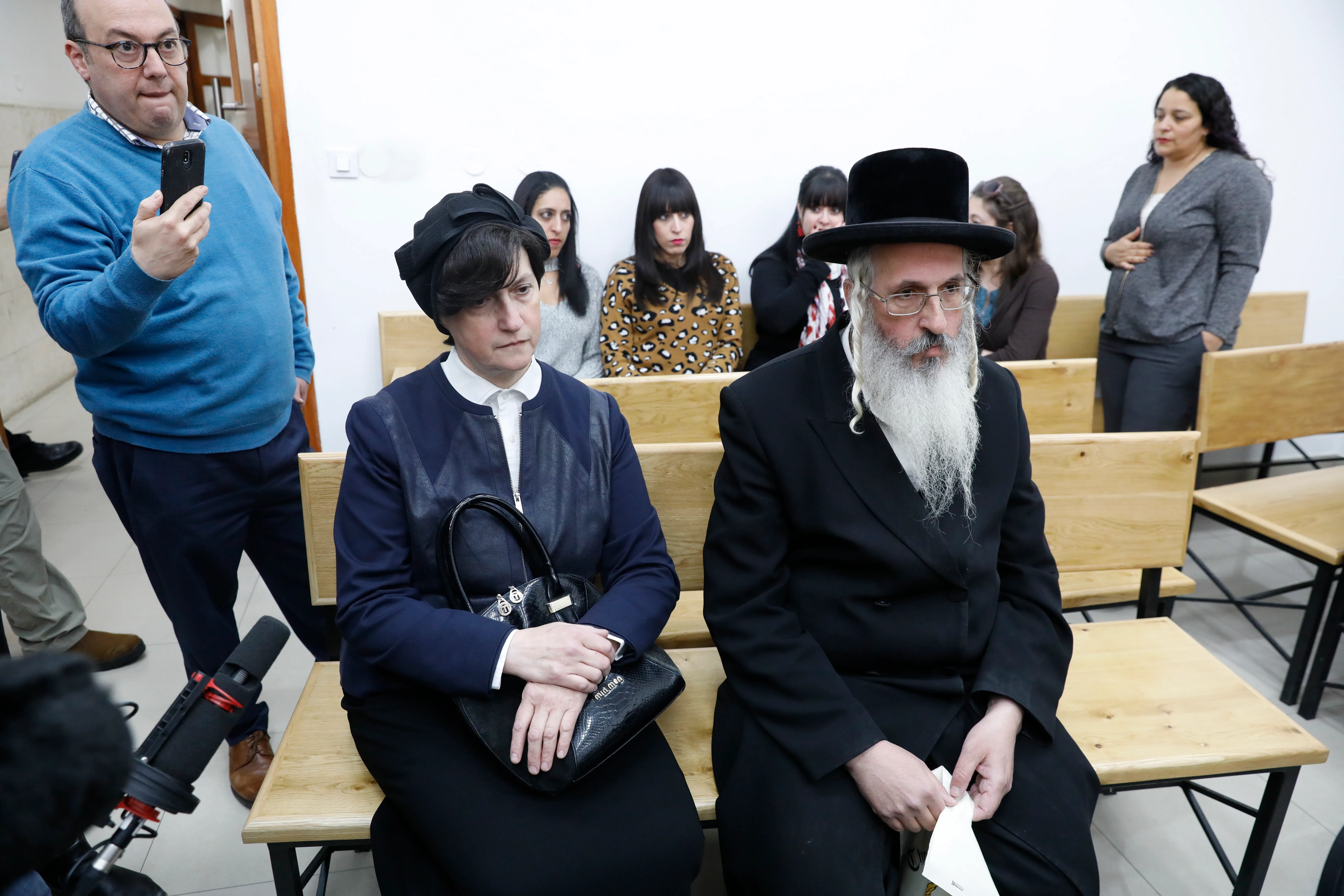 epa07416669 Three of the alleged abuse victims, Australian Citizens from Melbourne, Elly Sapir (background, L), Dassi Ehrlich (background, C) Nicole Meyers (background, R) former students of Malka Leifer (2-L), an ultra-Orthodox Jewish woman and her family attend the evidence stage of the Malka Leifer trial at the District court of Jerusalem, 06 March 2019. Israeli media reports that former Israeli Health Minister Yaakov Litzman was questioned by the police on suspicion of breach of trust and obstruction of justice on suspicion of attempting to prevent the extradition of ultra-Orthodox Jewish citizen of Australia Malka Leifer, a former Melbourne school principal wanted in Australia on suspicion of sexually abusing students.  EPA/ABIR SULTAN