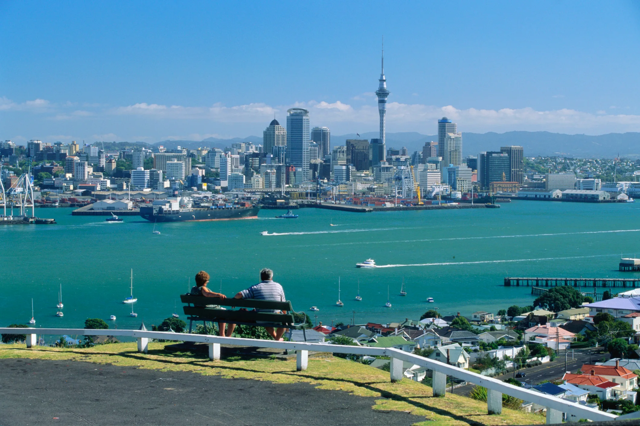 Couple looking out over downtown Auckland skyline and harbour.
