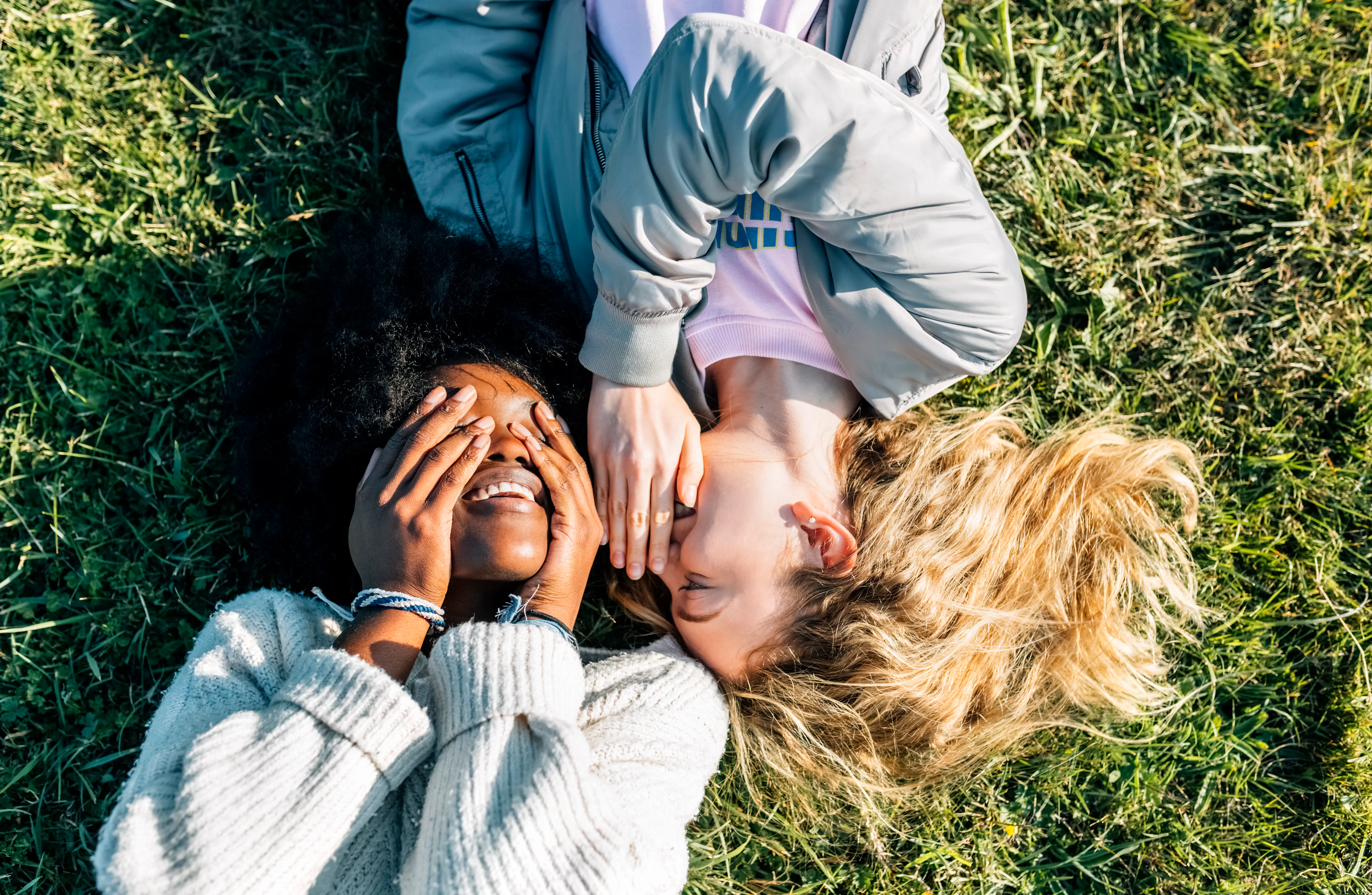 Woman covering her eyes and woman covering her mouth. 