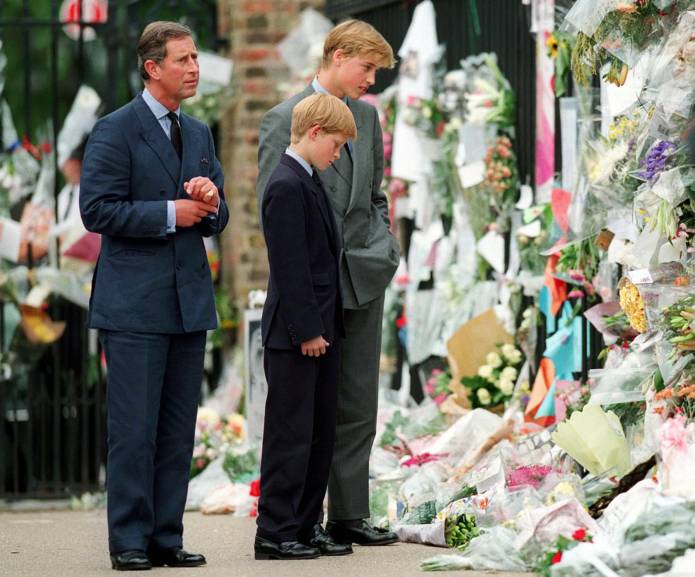 LONDON, ENGLAND - SEPTEMBER 5: The Prince of Wales, Prince William and Prince Harry look at floral tributes to Diana, Princess of Wales outside Kensington Palace  on September 5, 1997 in London, England.   (Photo by Anwar Hussein/WireImage)