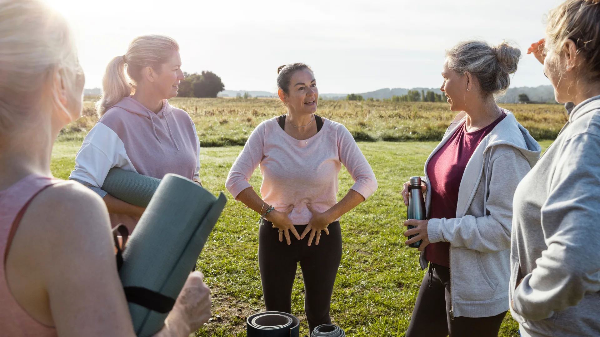 women standing in circle with yoga mats