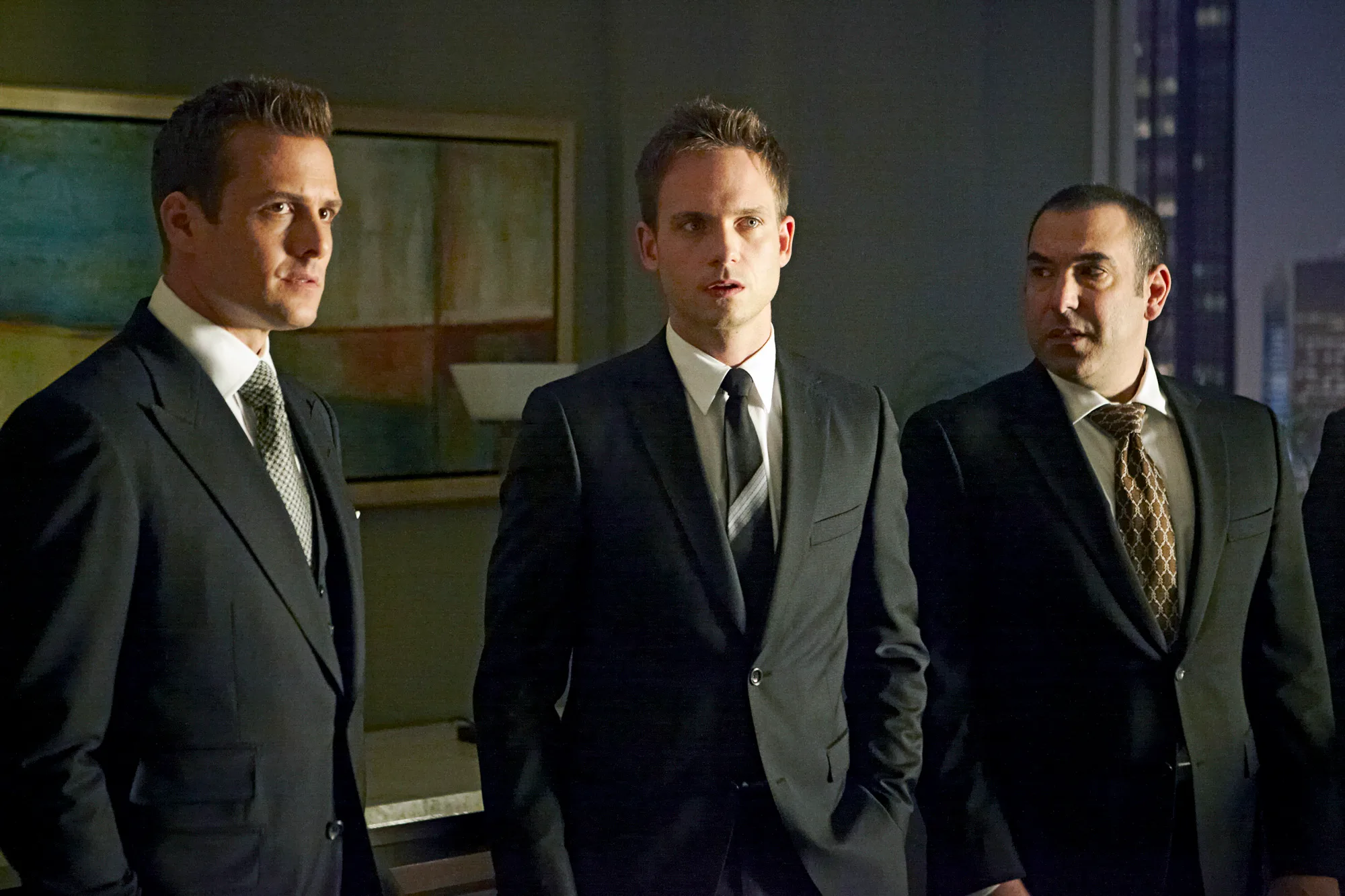 Gabriel Macht as Harvey Specter, Patrick J. Adams as Mike Ross, Rick Hoffman as Louis Litt in Suits. 