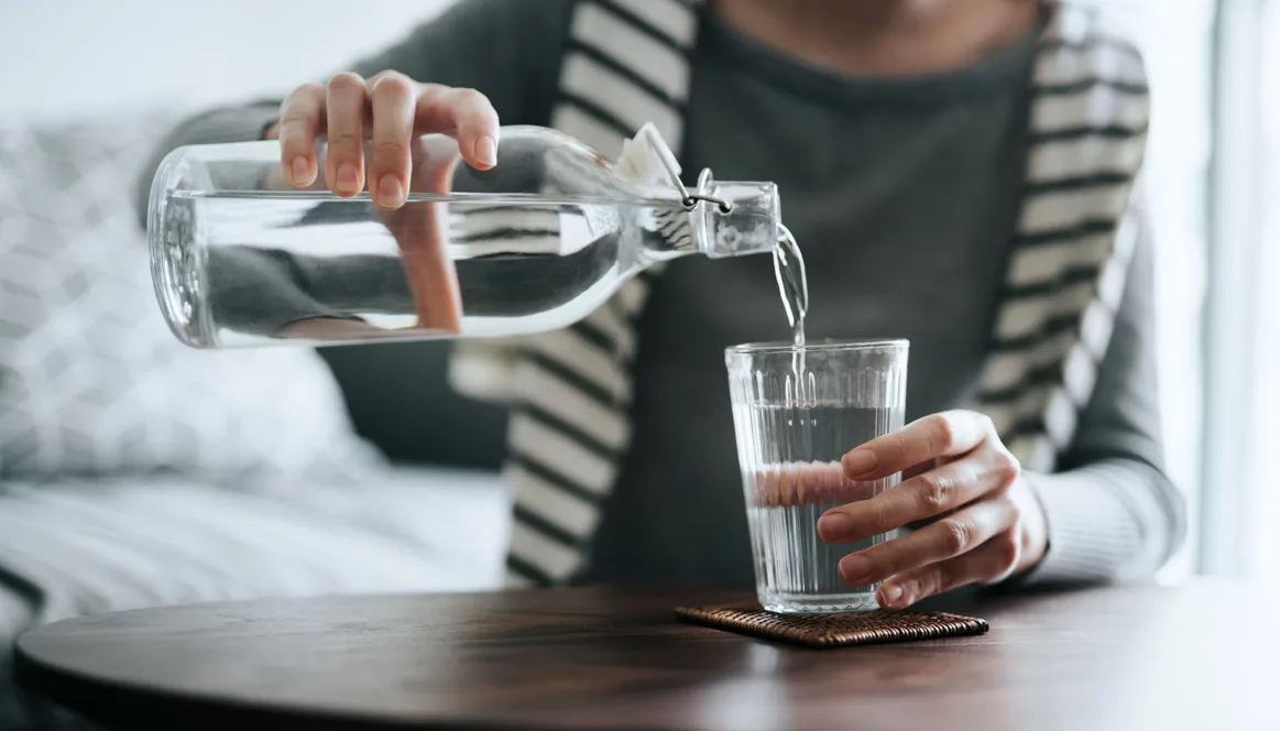woman pouring water into a glass