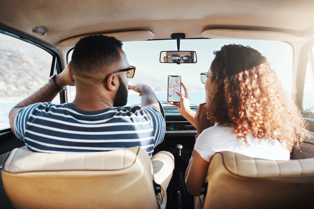 Shot of a young couple using gps on their mobile phone during a road trip.