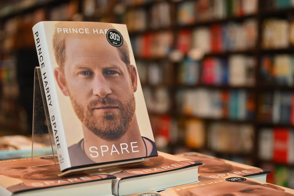 Book display of "Spare" by Prince Harry, featuring his portrait on the cover, in a bookstore setting.