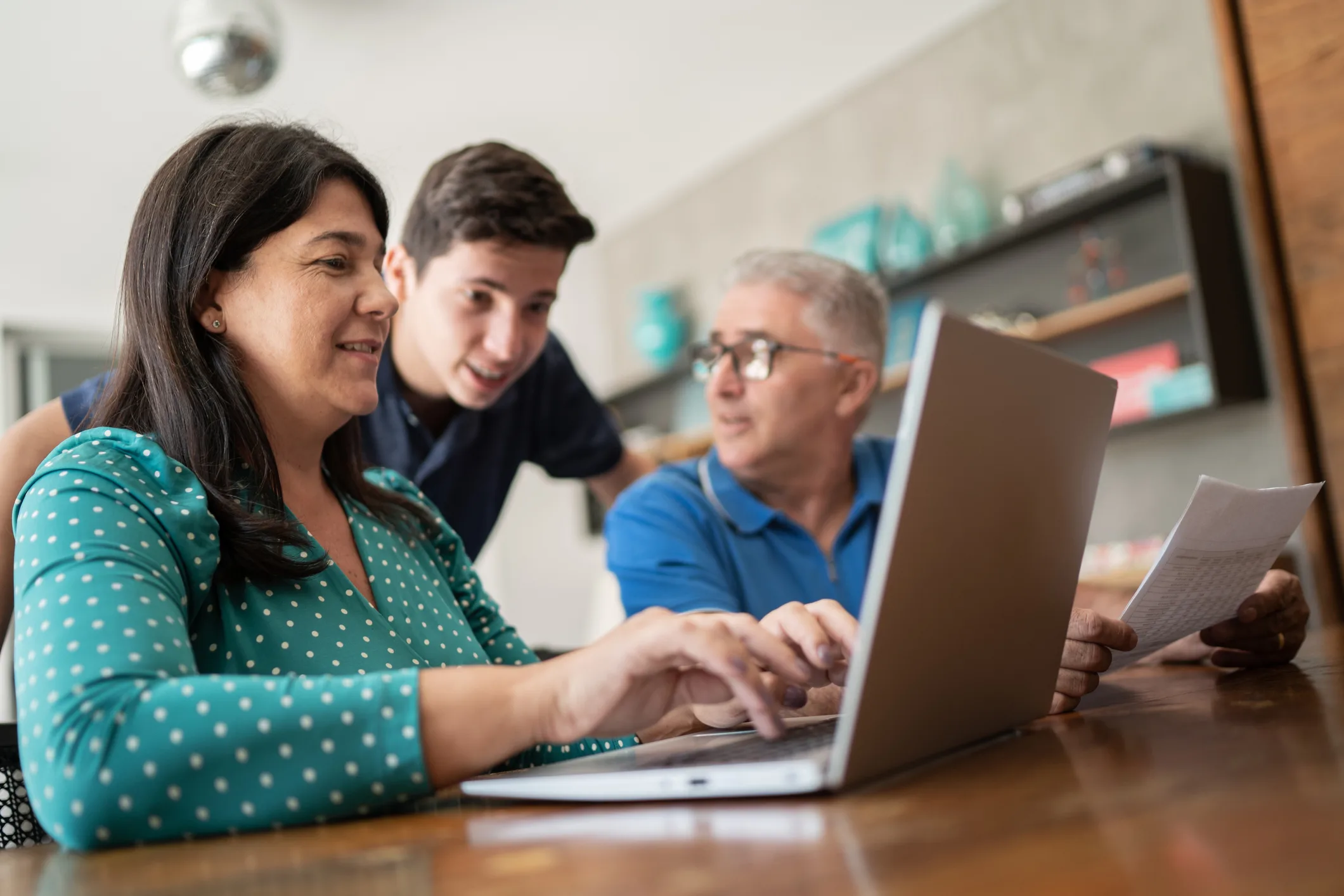 Parents doing home finances and talking to teenager son