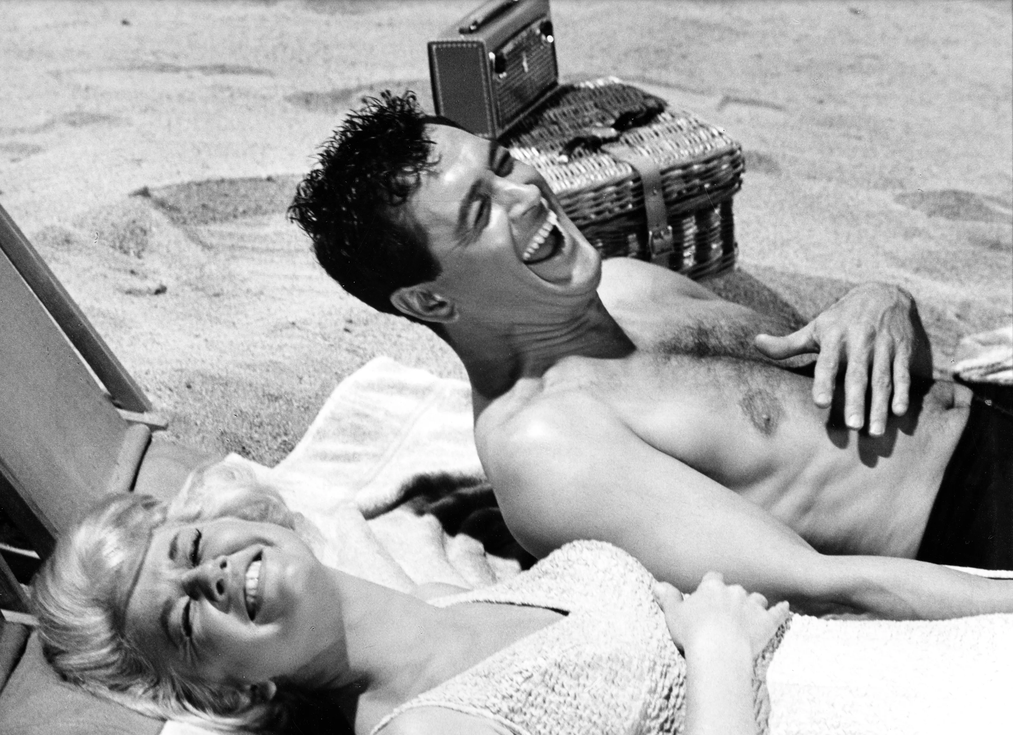Actress Doris Day and actor Rock Hudson laughing at the beach in a scene of "Lover Come Back" at Los Angeles, California in 1960. (Photo by Leo Fuchs/Getty Images)