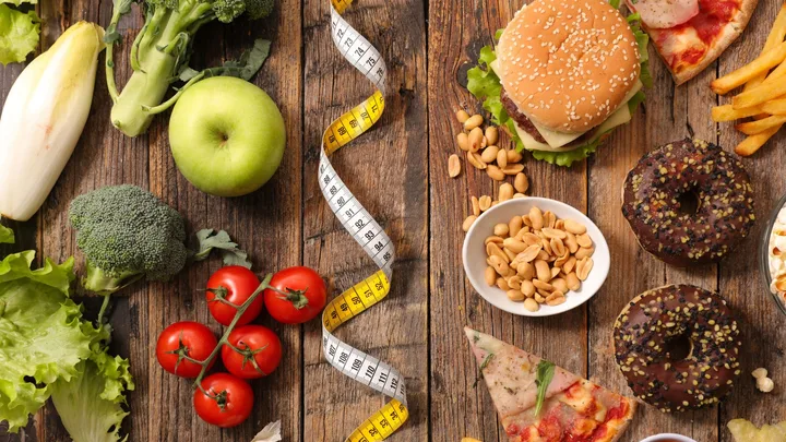 Healthy foods like vegetables and apples on left, junk foods like burgers and donuts on right, divided by a measuring tape.