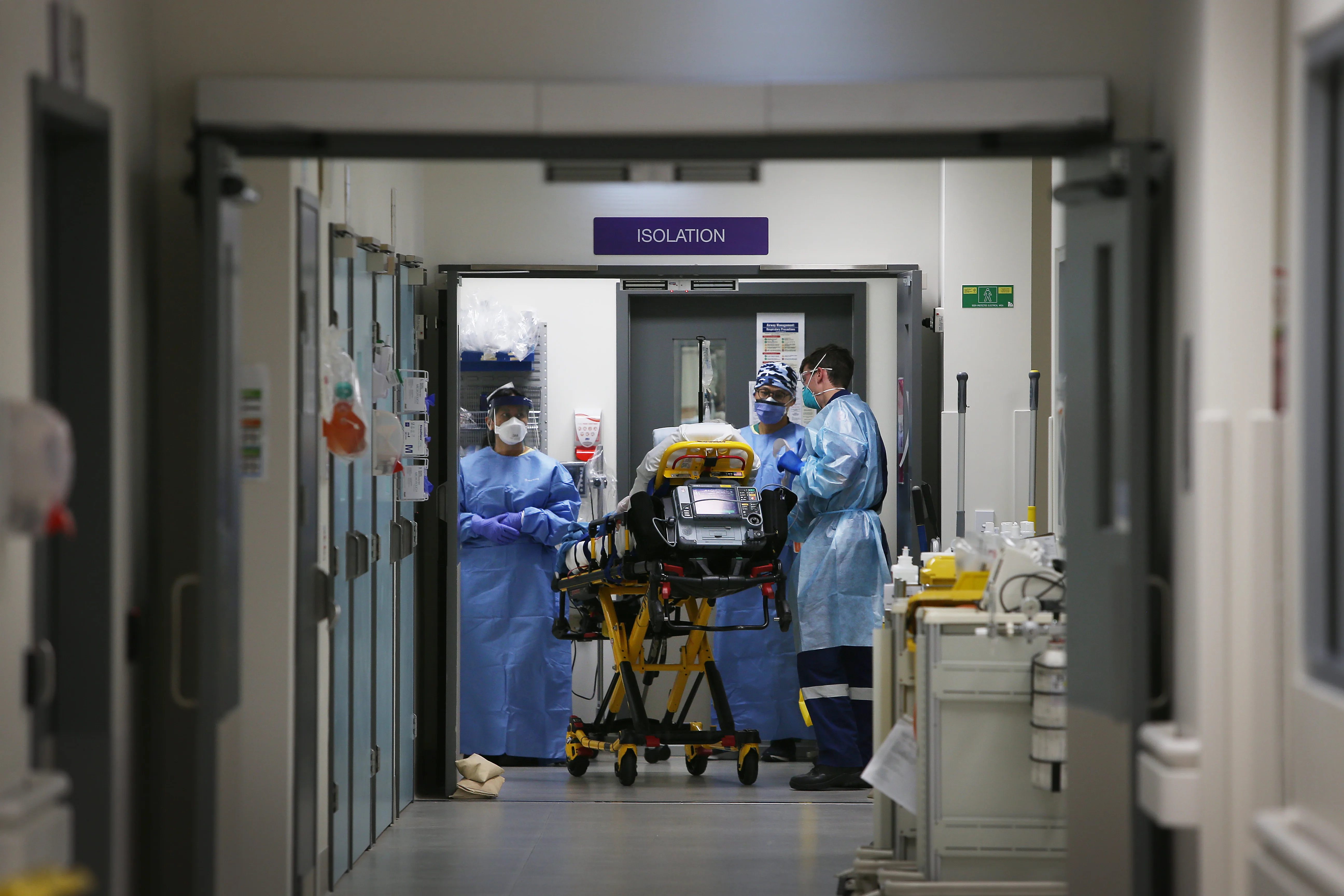 SYDNEY, AUSTRALIA - JUNE 04: Emergency Medicine Specialist  Dr Kevin Maruno and medical team take a suspected COVID-19 patient in to the isolation ward in the Red zone of the Emergency Department at St Vincent's Hospital on June 04, 2020 in Sydney, Australia. One of Australia's most iconic hospitals, St Vincent's was founded in 1857 and functions as a full service acute public teaching hospital predicted to see up to 60,000 patients come through the Emergency Department in 2020. During the COVID-19 outbreak in Australia, the hospital set up a separate COVID-19 section of the emergency department, utilising a newly built section of the hospital to have a Red (COVID-19) zone and a Green (general emergency zone) with specific rotating staff to prevent infection spread. In the wake of the worst of the COVID-19 outbreak, staff at St Vincent's hospital say they are now seeing a new wave of patients presenting with mental health, drug and alcohol abuse and domestic violence issues which have been amplified by social and economic changes during the COVID-19 lockdown. To more effectively treat patients presenting to the Emergency Department with mental health as well as drug and alcohol-related conditions, the hospital was granted over $12 million from the New South Wales government and more than $4 million from private donors to start the groundbreaking St Vincent's Hospital Psychiatric Alcohol and Non-Prescription Drug Assessment (PANDA) Unit. This has included reconfiguring the physical space in the Emergency Department to directly address projected growth in emergency presentations. Earlier this year the hospital held a pilot care program called Flexi Clinic specifically for Aboriginal patients, believed to be the first of its type in a hospital emergency department in Australia it was formally introduced in June, 2020.  (Photo by Lisa Maree Williams/Getty Images)