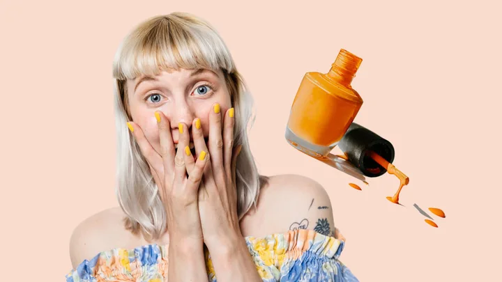 Woman with surprised expression, yellow nails, and an orange nail polish bottle spilling.
