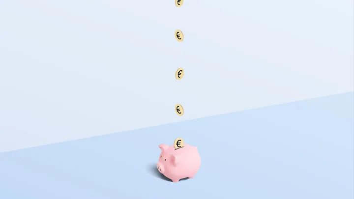 Pink piggy bank catching falling euro coins on a blue background.