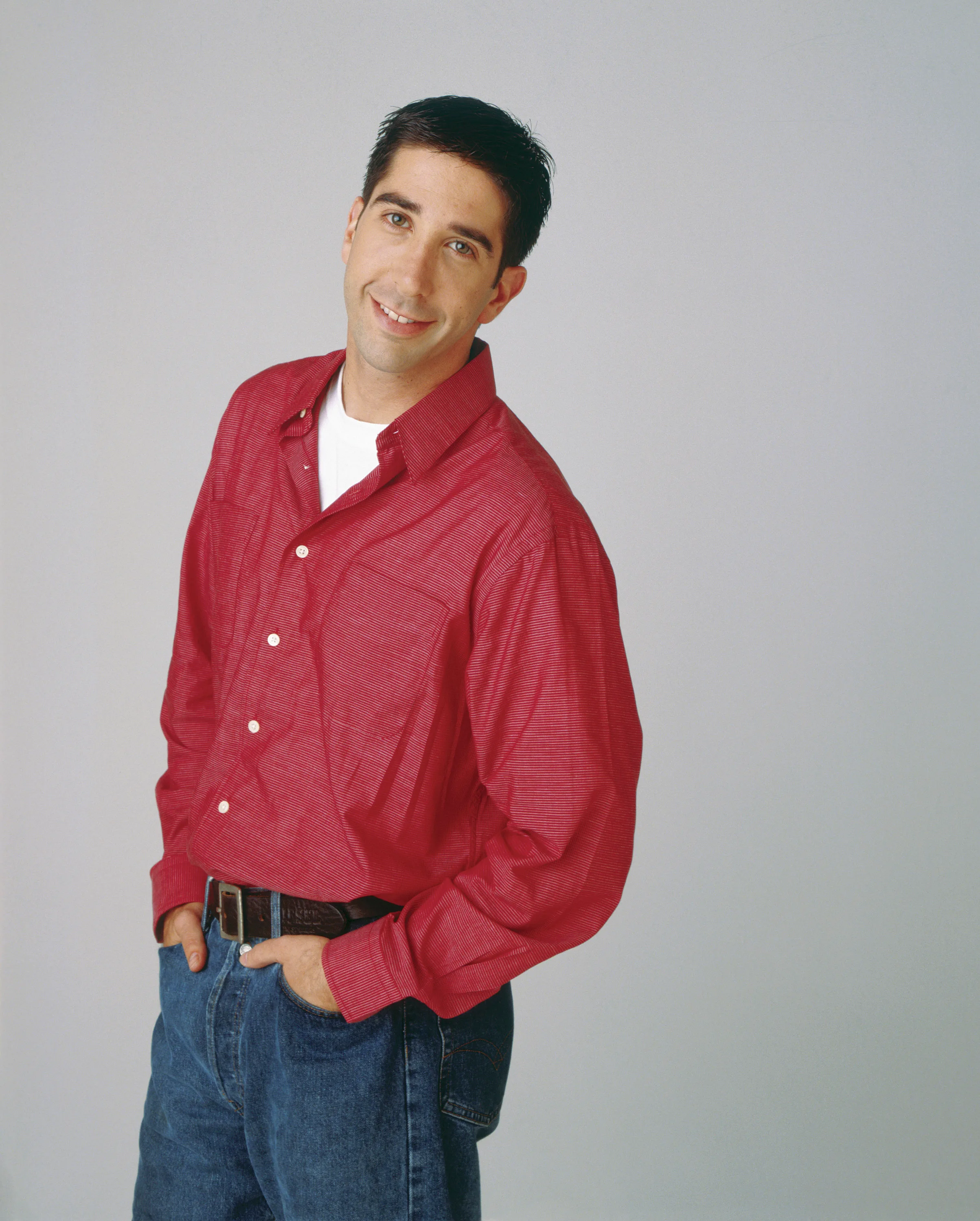 David Shwimmer as Ross Geller wearing a red button shirt and jeans.