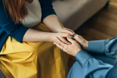 Two women holding hands.