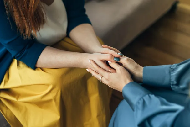 Two women holding hands.
