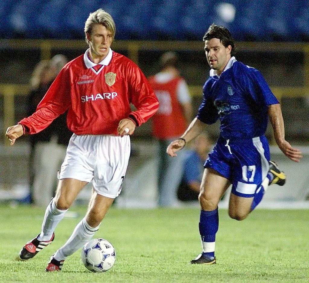 RIO DE JANEIRO, BRAZIL: Manchester United golden boy David Beckham (L) moved the ball past Jim Tsekinis of South Melbourne during their World Club Championship match 11 January 2000 at the Maracana Stadium in Rio de Janeiro. (ELECTRONIC IMAGE) AFP PHOTO/Antonio SCORZA (Photo credit should read ANTONIO SCORZA/AFP via Getty Images)