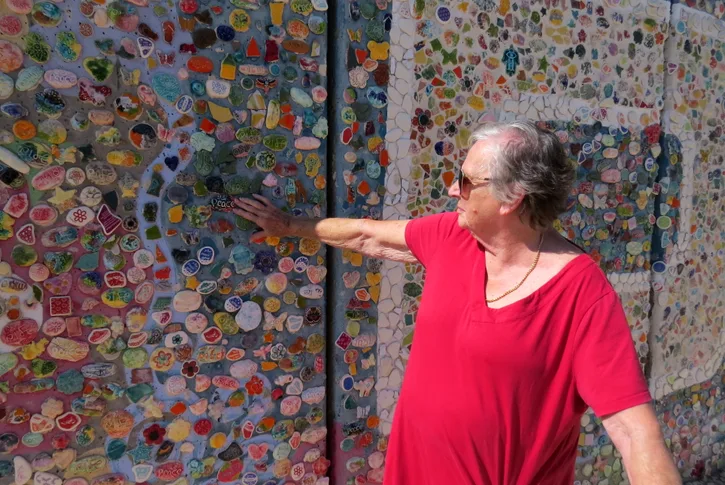 Roni reaches out to touch the wall that divides Israel from Gaza. It is covered in mosaic tiles to symbolise peace.