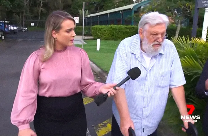 A man using a walker is questioned by a female TV journalist. 