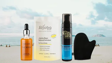 Self-tanning products with a beach background: Tan-Luxe Drops, Jojoba Exfoliant, Bondi Sands Foam, and mitt.