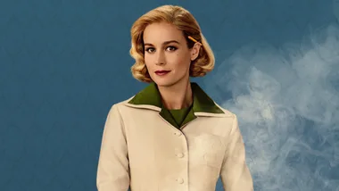 Woman with short blonde hair in vintage outfit against a blue background.